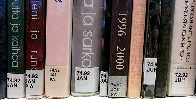 Books in a Finnish library featuring a version of the Dewey Decimal System.