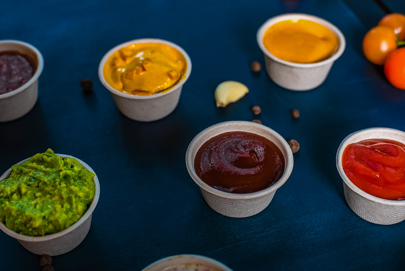 A selection of sauces in small paper cups.
